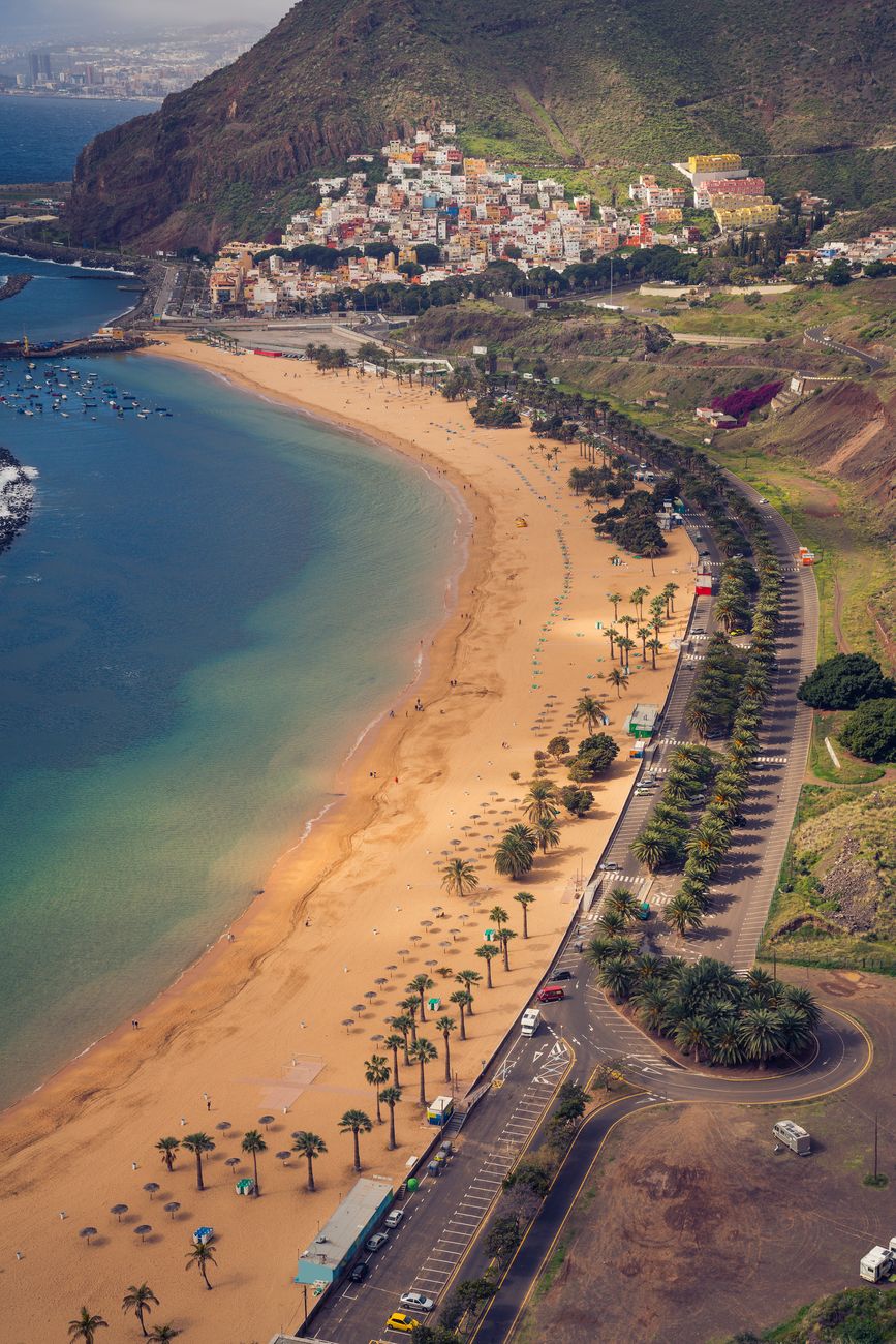 Stunning aerial view of Playa de Las Teresitas with vibrant waters and lush surroundings in Tenerife.